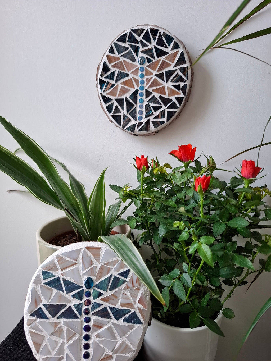 Dragonfly mosaics on the wall surrounded by plants