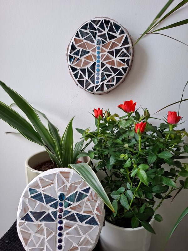 Dragonfly mosaics on the wall surrounded by plants