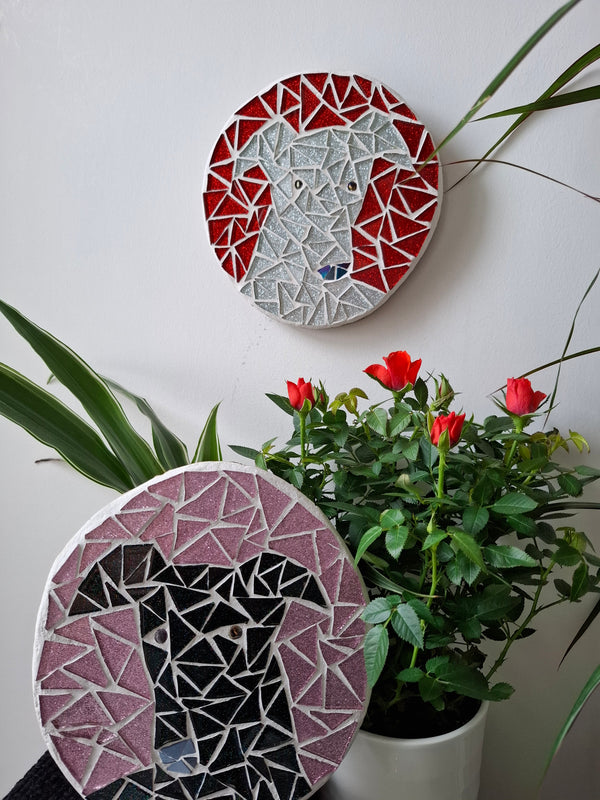 Dog mosaics on the wall surrounded by plants
