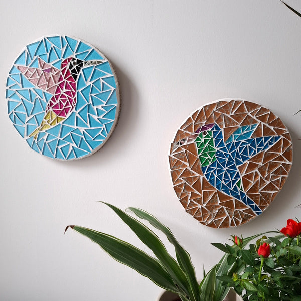 Bird mosaics on the wall surrounded by plants
