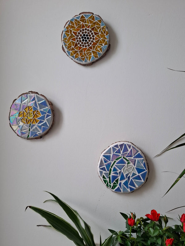 Flower mosaics on the wall surrounded by plants
