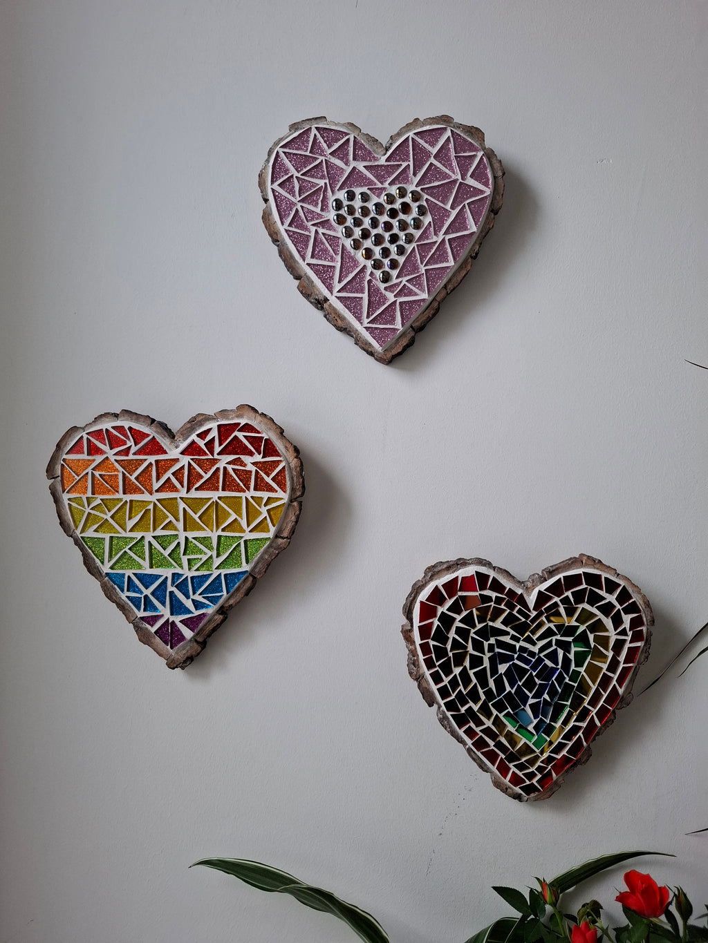 Heart mosaics on the wall surrounded by plants