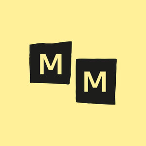 Two black square patches, each with a pale yellow letter M, arranged diagonally on a solid pale yellow background.