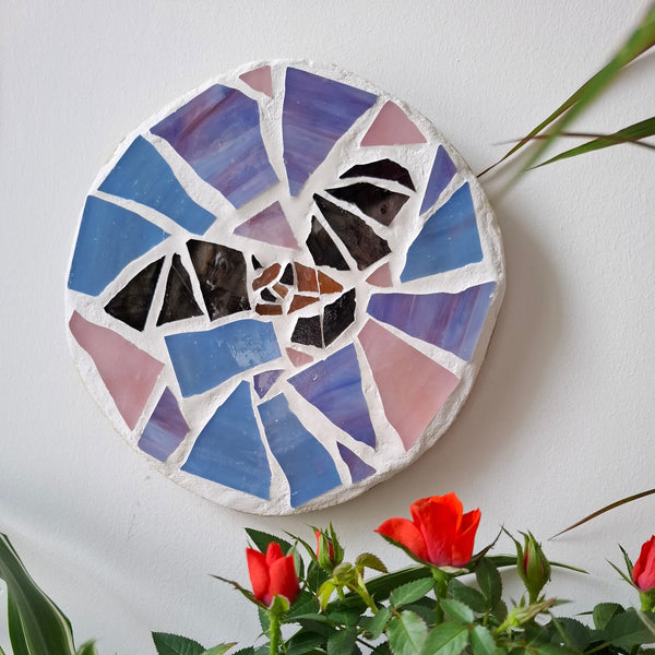 Bat mosaic on the wall surrounded by plants 