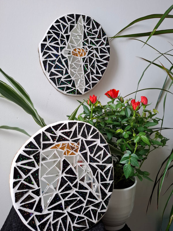 Bat mosaics on the wall surrounded by plants 