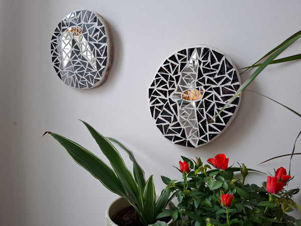 Bat mosaics on the wall surrounded by plants 