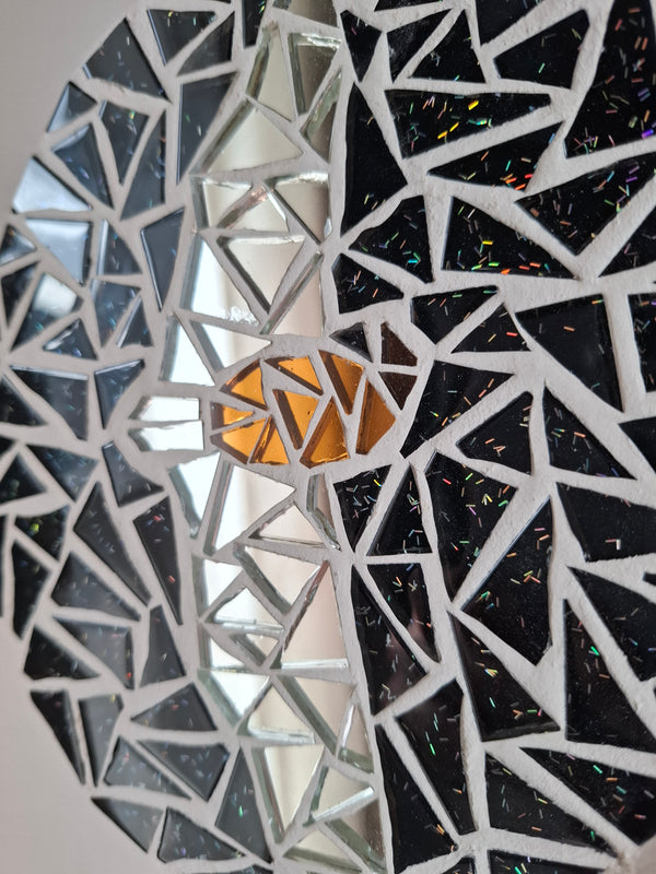 Close up of an oval bat mosaic artwork, showing the rustic wood edge.