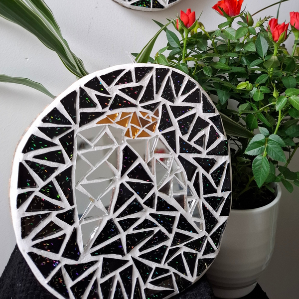 Bat mosaic on the table surrounded by plants 