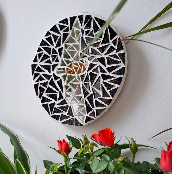 Bat mosaic on the wall surrounded by plants 
