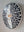 Side view of an oval bat mosaic artwork, showing the rustic wood edge.