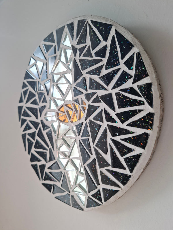 Side view of an oval bat mosaic artwork, showing the rustic wood edge.