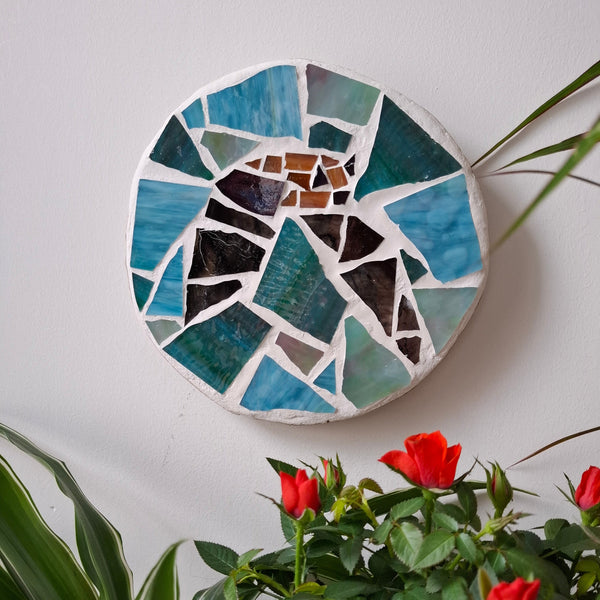 Bat mosaic on the wall surrounded by plants 