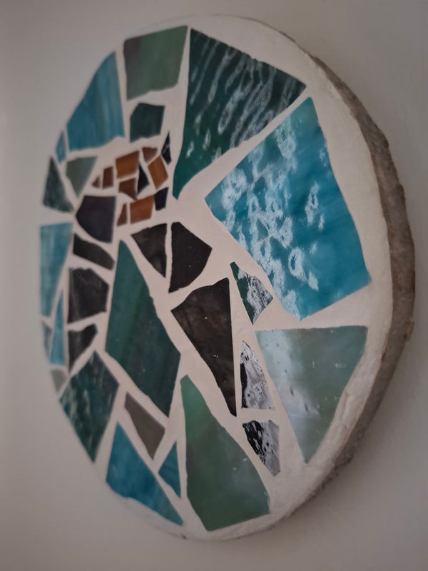 
Side view of a circular bat mosaic artwork, showing the rustic wood edge.