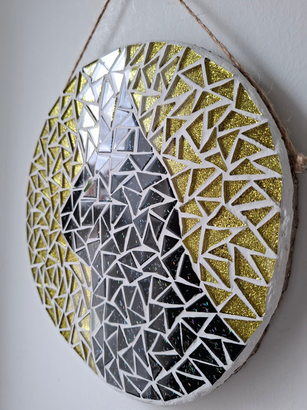 Side view of a circular cat mosaic artwork, showing the rustic wood edge.