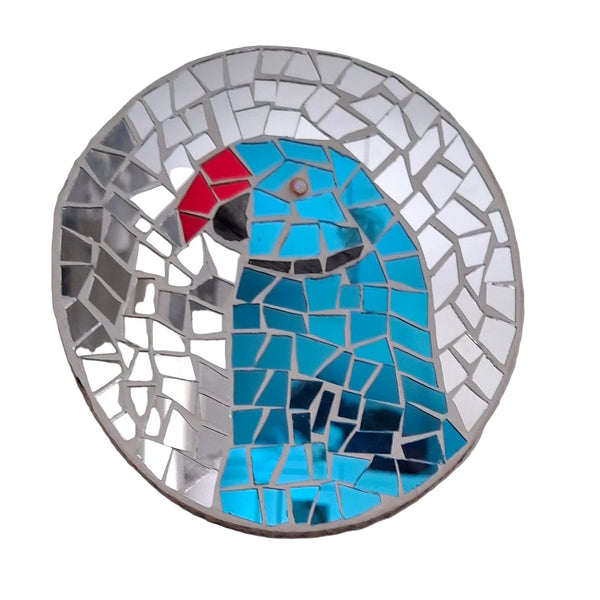 Circular mosaic wall art featuring a stylized parakeet design. Crafted with reflective blue mirror glass pieces on a reflective silver mirror background, set on rustic wood.
