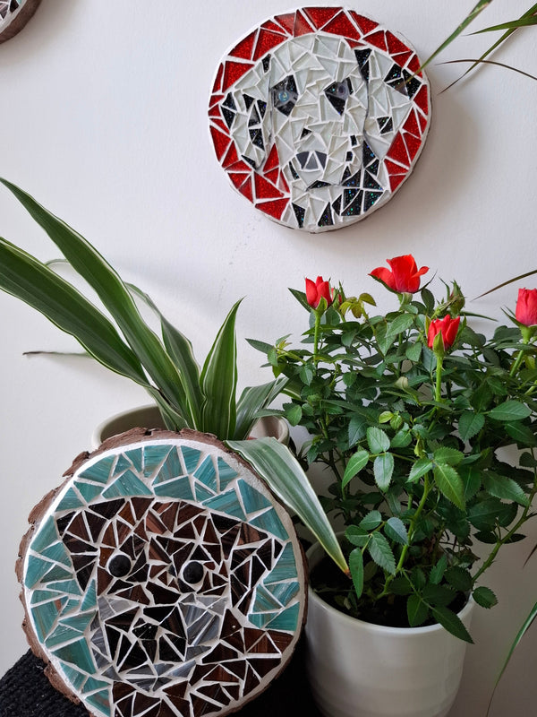 Dog mosaics on the wall surrounded by plants
