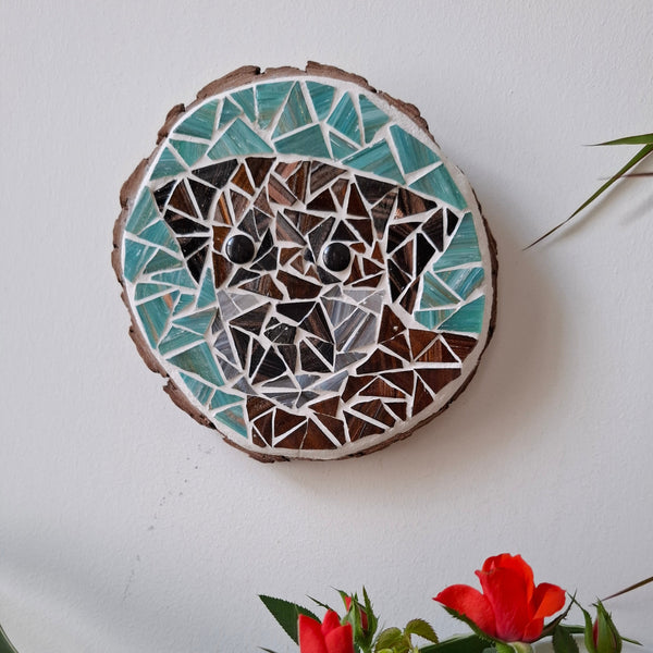 Dog mosaic on the wall surrounded by plants
