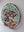 Side view of a circular dog mosaic artwork, showing the rustic wood edge.