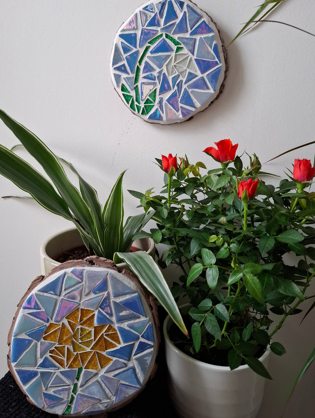 Flower mosaics on the wall surrounded by plants
