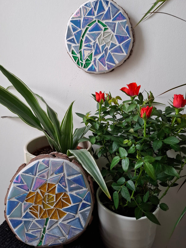 Flower mosaics on the wall surrounded by plants
