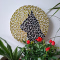 Cat mosaic on the wall surrounded by plants
