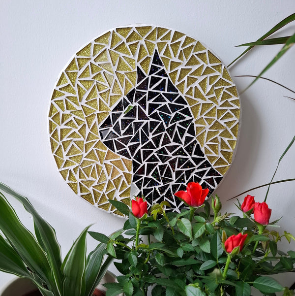 Cat mosaic on the wall surrounded by plants

