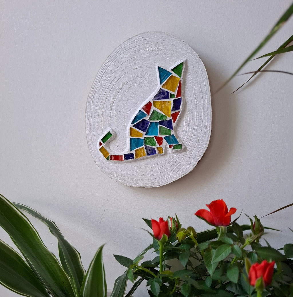 Cat mosaic on the wall surrounded by plants