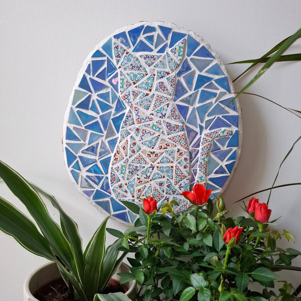 Cat mosaic on the wall surrounded by plants