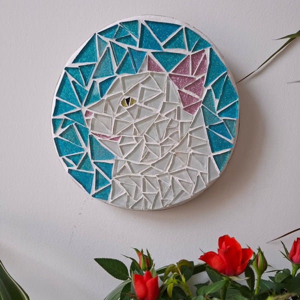 Cat mosaic on the wall surrounded by plants
