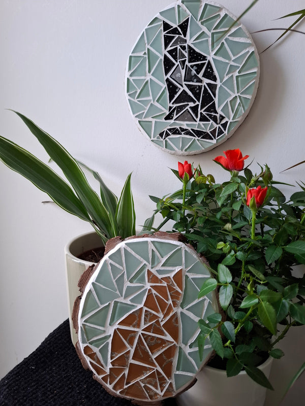 Cat mosaics on the table surrounded by plants