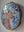 Side view of a circular dog mosaic artwork, showing the rustic wood edge.