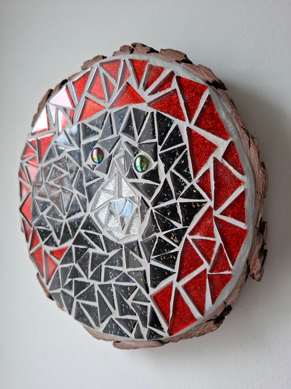 Side view of a circular dog mosaic artwork, showing the rustic wood edge.