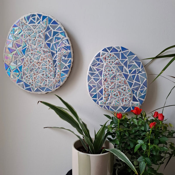 Dog and cat mosaics on the wall surrounded by plants