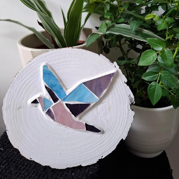 Dove mosaic on the table surrounded by plants