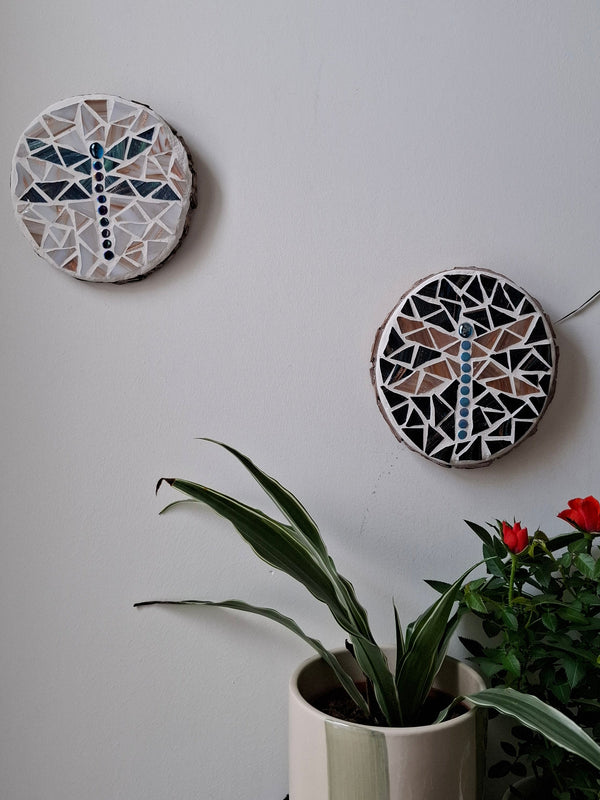 Dragonfly mosaicd on the wall surrounded by plants
