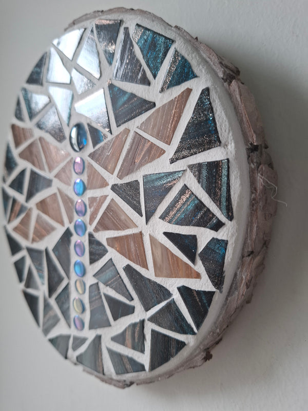 Side view of a circular dragonfly mosaic artwork, showing the rustic wood edge.