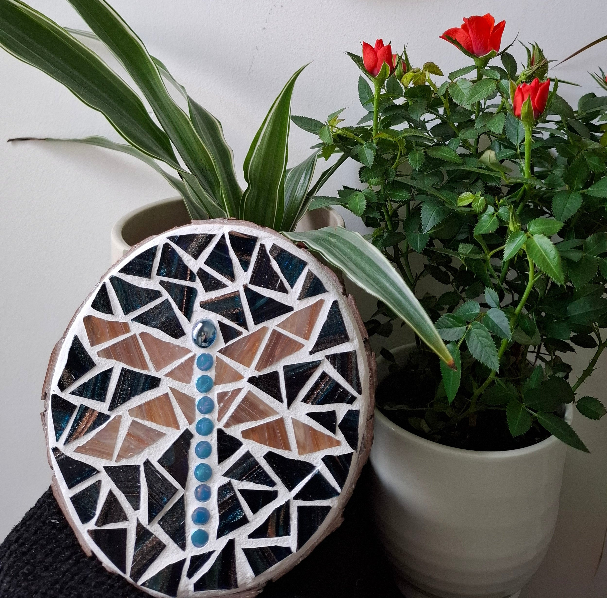 Dragonfly mosaic on the table surrounded by plants

