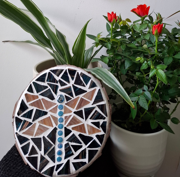 Dragonfly mosaic on the table surrounded by plants
