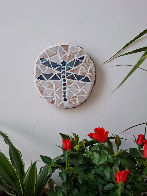 Dragonfly mosaic on the wall surrounded by plants