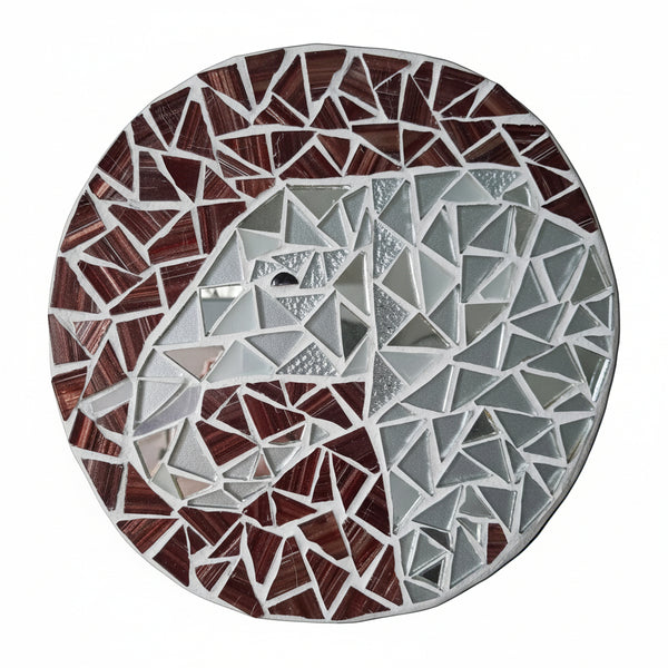 Circular mosaic wall art featuring a stylized elephant design. Crafted with glittery silver and reflective silver mirror glass pieces on a gold-dusted mahogany background, set on rustic wood.
