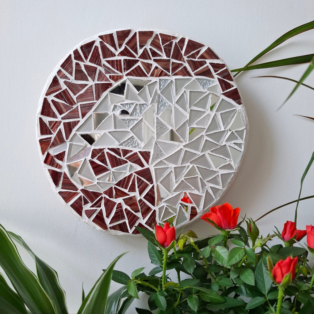 Elephant mosaic on the wall surrounded by plants
