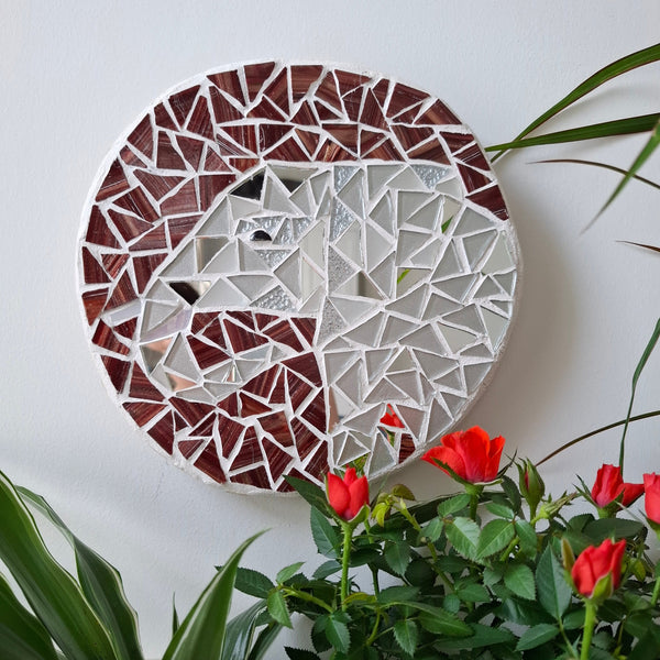 Elephant mosaic on the wall surrounded by plants
