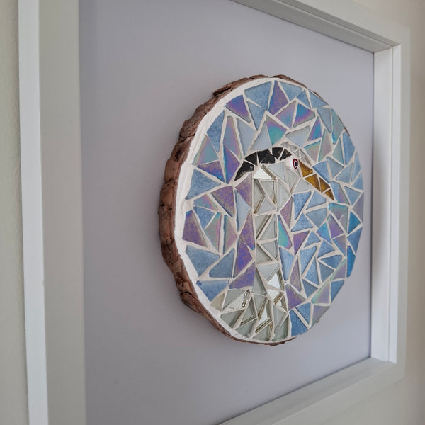 Circmosaic featuring a silver and white heron on an iridescent blue background in a white frame