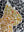 Side view of a circular cat mosaic artwork, showing the rustic wood edge.