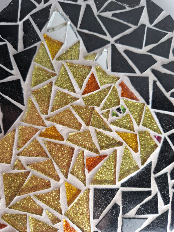 Side view of a circular cat mosaic artwork, showing the rustic wood edge.
