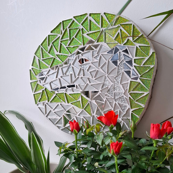 Dog mosaic on the wall surrounded by plants
