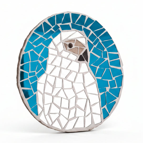 Circular mosaic wall art featuring a stylized grey parrot design. Crafted with reflective silver mirror glass pieces on a reflective blue mirror background, set on rustic wood.