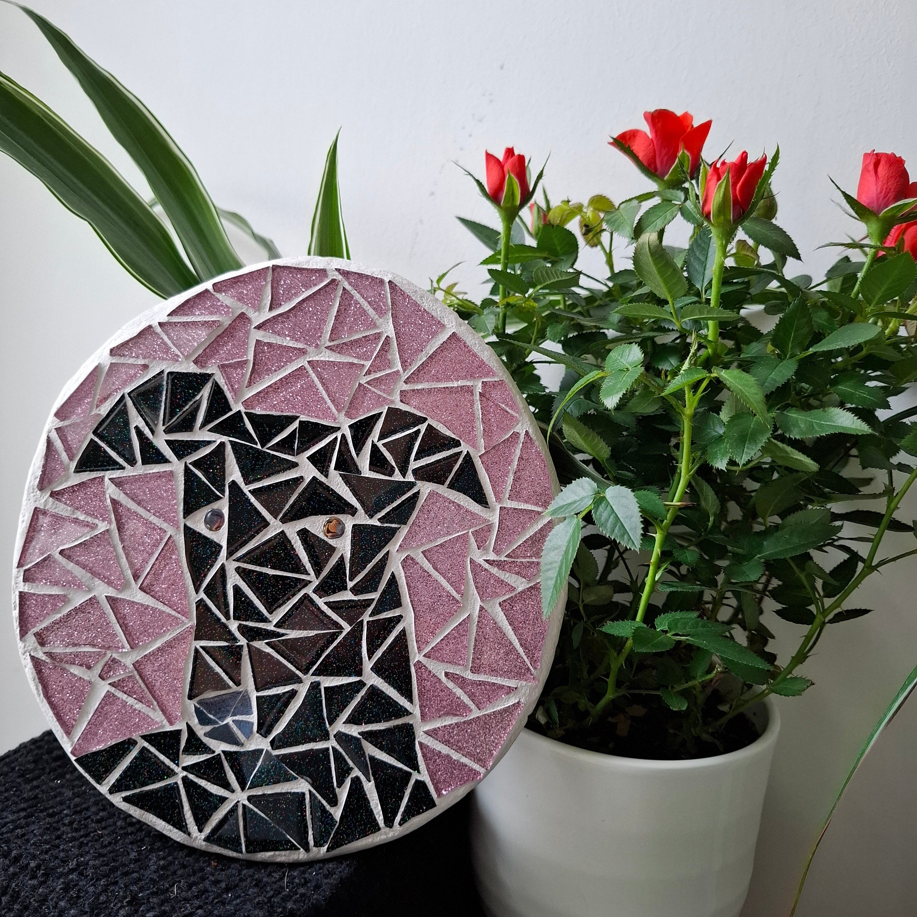 Dog mosaic on the table surrounded by plants
