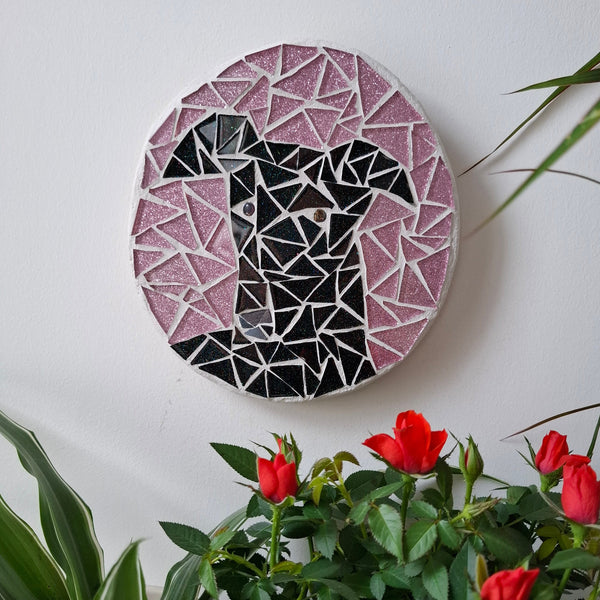 Dog mosaic on the wall surrounded by plants
