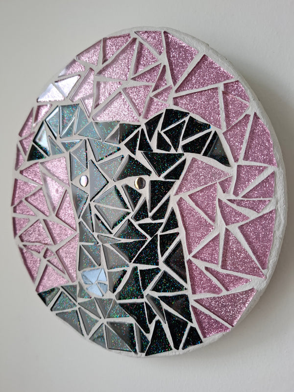 Side view of a circular dog mosaic artwork, showing the rustic wood edge.
